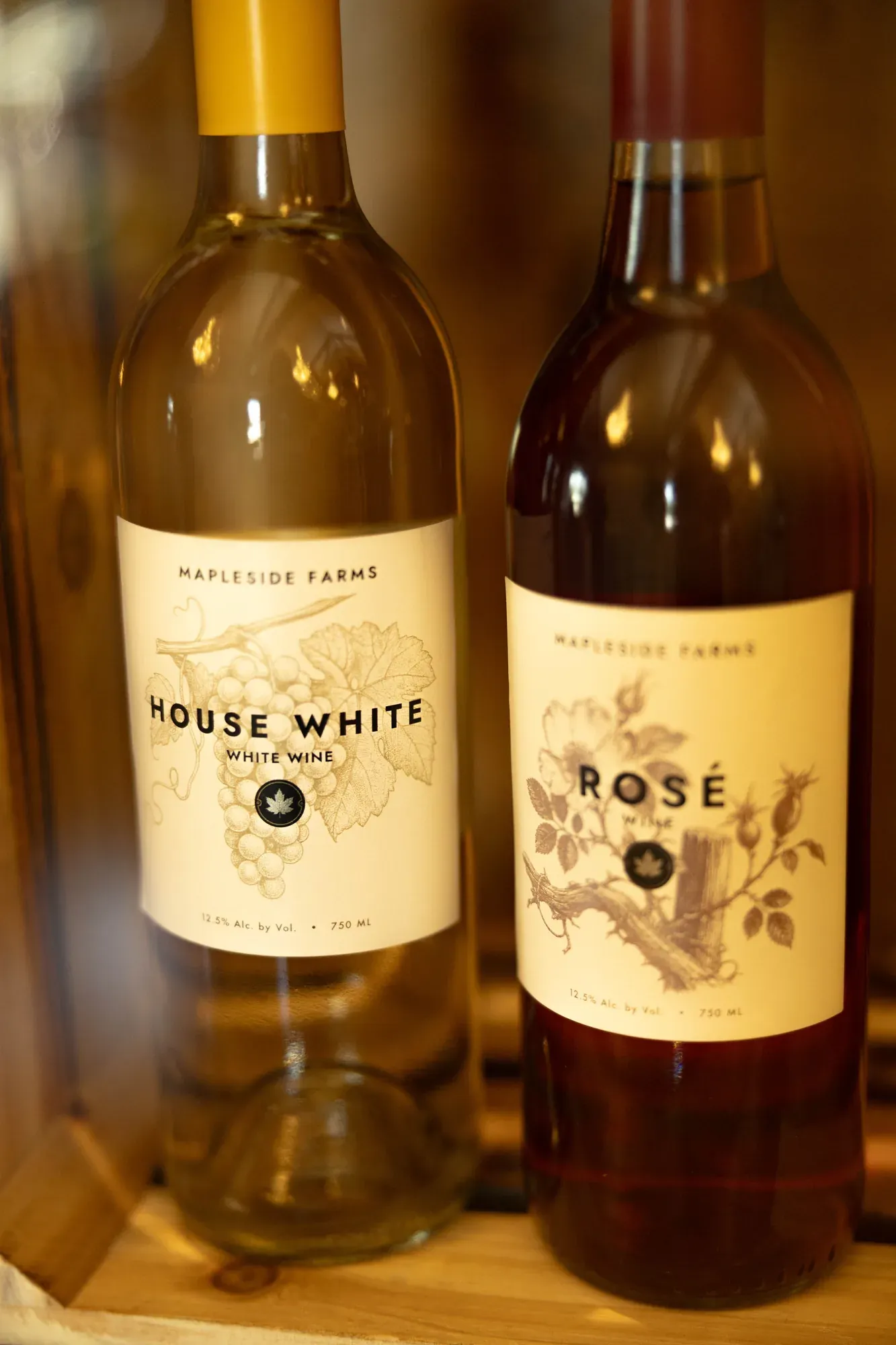 Bottles of Mapleside Farms House White and Rosé standing in a wooden crate